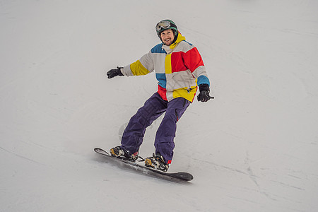 冬季在滑雪度假胜地的男性滑雪车单板娱乐森林假期空气运动员木板游客头盔男生图片