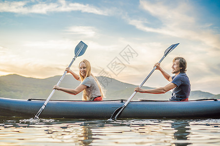男人和女人在海岛背景下的皮划艇上游泳 皮划艇概念 与父亲母亲家人在海上划皮划艇的概念冒险独木舟乐趣漂流女孩夫妻夹克背心太阳闲暇图片