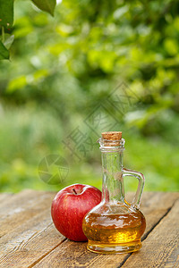 玻璃瓶中的苹果醋和木板上新鲜的红苹果桌子食物水果玻璃果汁红色绿色液体瓶子乡村图片