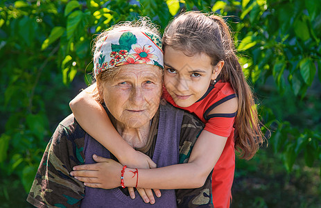 孙女拥抱和爱她奶奶 有选择的专注童年祖母快乐女士花园母亲家庭子女女孩乐趣图片