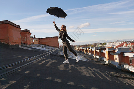 有雨伞的女人在俄罗斯圣彼得堡的屋顶上很快乐 城市风景图片