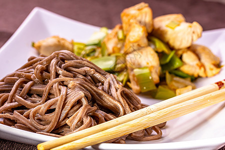 日本面条Yakisoba和浅本鸡肉及蔬菜的日本黄麦面食物白色胡椒健康美食炒面大豆桌子洋葱盘子图片