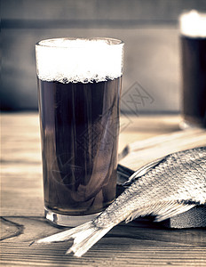 两杯啤酒和干鱼啤酒瓶美味清新剂眼镜盐渍桌子食物酒精酒吧砧板图片