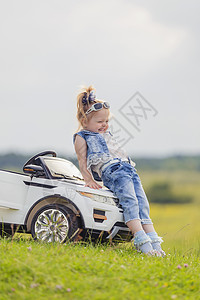 女孩站在婴儿车旁边车辆孩子们娱乐公园后院快乐钱包乐趣运输玩具图片