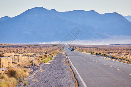 以大山为背景 作为穿越沙漠平原的公路干道图片