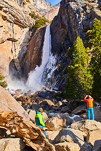 享受初春寒冷的洛威Yosemite瀑布风景的游客图片