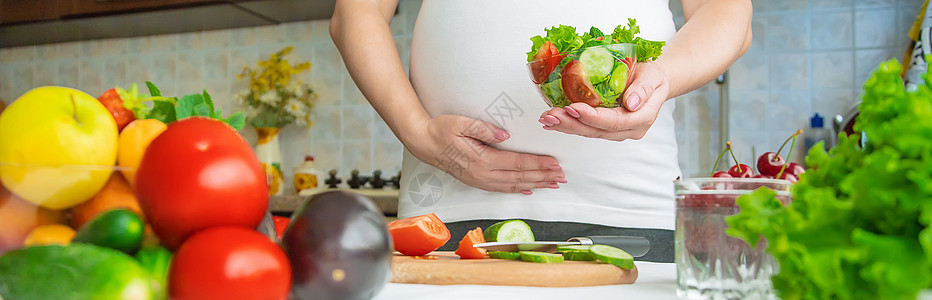 孕妇吃蔬菜和水果 有选择性地集中注意力肚子腹部素食主义者饮食女士沙拉父母横幅厨房怀孕图片