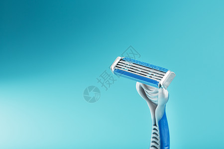 蓝色背景上新的剃须机的刀片刮胡子胡须机器男人男士润滑剂金属洗手间安全剃刀图片