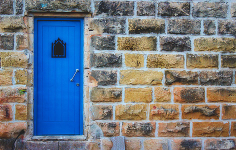 蓝色门 在一块粗糙的大石头墙外面图片