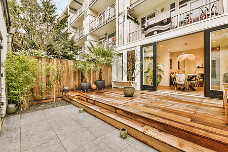 现代欧洲之家的后院车牌住宅草地花园桌子露台门廊绿色红色椅子木头图片