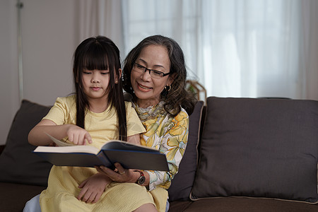 在家读孙女书的外婆奶奶闲暇学习成人快乐房间阅读孙子教育家庭祖父母图片