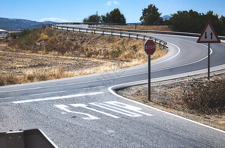 乡村场景中双向十字路口道路上的停车标志和标记图片