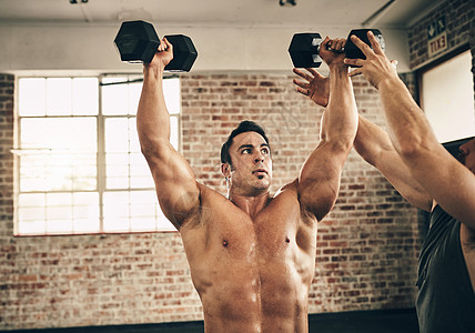 这是健身房朋友的功劳 两个健壮而坚定的年轻男人在健身房里 互相助力地锻炼体重图片