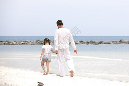 可爱的小女孩握着父亲的手 爸爸和女儿一起在海滩上玩耍 她很可爱幸福男人乐趣女孩阳光闲暇微笑喜悦笑声生活图片