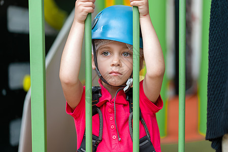 身着蓝防护头盔的可爱小女孩登山者 以及站在攀爬中心儿童游乐园的攀爬渔具休闲冒险生活方式挑战运动闲暇岩石娱乐攀岩乐趣图片