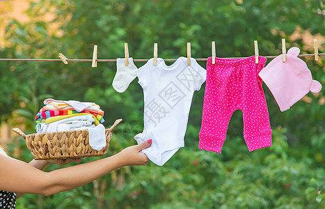 洗婴儿衣物 在新鲜空气中干枯床单 有选择的焦点棉布产妇母亲生活家庭边界洗衣乐趣亚麻女孩图片