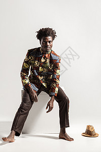 身着国家孔戈民族服装的非洲男子坐在立方体上图片
