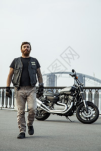 骑摩托车的人在暑假时摆着摩托车夹克运动车辆男性黑色摩托冒险皮革头盔发动机图片