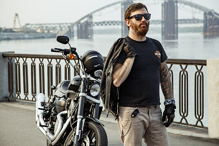 骑摩托车的人在暑假时摆着摩托车黑色自由头盔夹克沥青发动机冒险男性成人街道图片