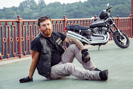 骑摩托车的人在暑假时摆着摩托车头盔男人自由摩托街道发动机自行车男性夹克冒险图片