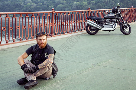 骑摩托车的人在暑假时摆着摩托车男人发动机沥青夹克成人摩托街道自由车辆皮革图片