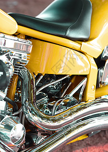 带有镀铬物皮革座椅的定制设计摩托车的特写镜头 一辆黄色豪华摩托车的细节 在汽车零部件和服务店升级到带有昂贵电机部件的摩托车图片