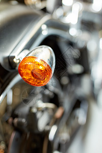 摩托车尾灯的特写后视图 一辆模糊的黑色老式摩托车上的橙色转向灯 一辆现代镀铬物运输车 保养闪亮的经典复古定制自行车图片