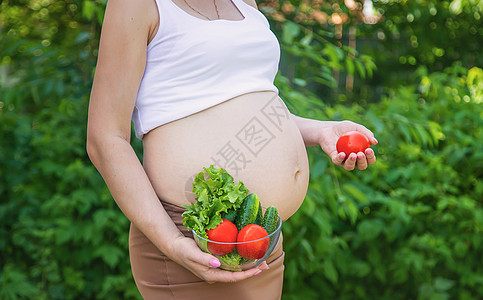 孕妇手里拿着蔬菜 有选择的专注点腹部父母幸福女孩食物母性女性福利厨房营养图片