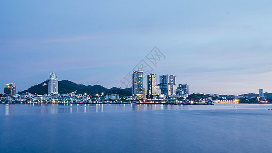 泰国黄昏时以背景和小山为建筑的海景全景商业海洋旅行天际风景摩天大楼蓝色地标倒影反射图片