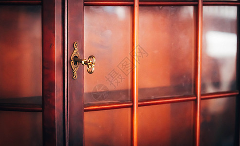 木板壁玻璃门家具上的金色古金色钥匙; 内阁家具图片