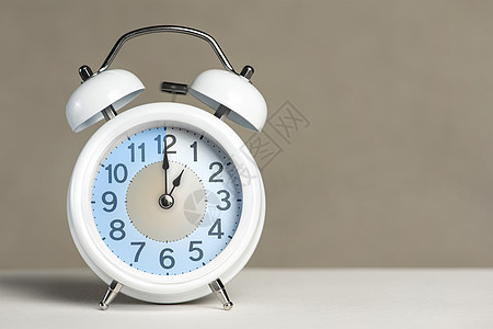 报警一小时 一个白色的闹钟在一张白色的桌子上 时钟指针指向小时 时间翻译 设置 1 00 或 13 00 的闹钟 复制空间图片