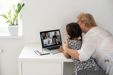 快乐的外祖母和孙女在家通过笔记本电脑一起视频聊天幸福技术房子祖母家庭成人孩子女士奶奶孙子图片