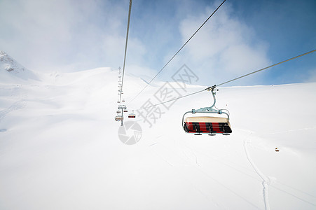 高山顶的露天升空 下坡滑雪 日落之日被雪田包围 天气好时滑雪度假村斜坡高度运动山脉旅行蓝色滑雪者电缆缆车升降椅滑雪板图片