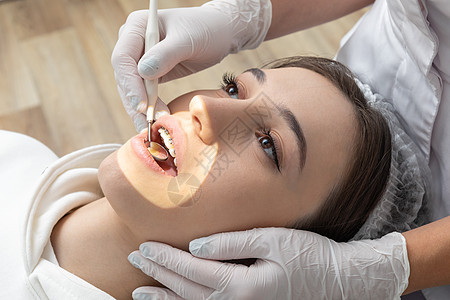 在牙科诊所进行牙科检查的年轻女子 牙医用牙镜检查病人的牙齿药品健康成人女性口腔科口服女士牙疼设备工具图片