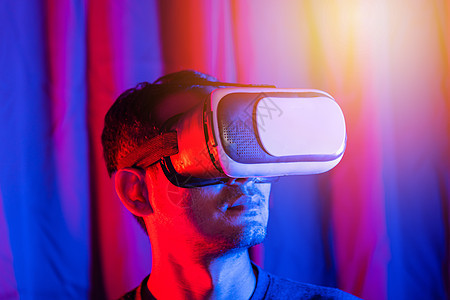 亚洲英俊男子穿着VR头盔 在家里穿紫蓝背景和紫色背景时兴奋情绪激动娱乐游戏创新商业洞察力男性享受男人工具眼镜图片