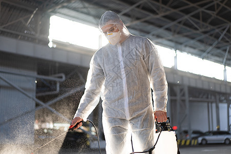检疫期间穿着白色防护服的男子喷洒表面抗菌消毒剂喷雾器环卫工人套装化学品卫生防护工作服生物工具疾病保健图片