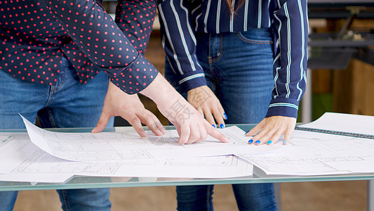男性建筑师在蓝图上指着什么绘画工作框架活动草图办公室专家铅笔职业桌子背景图片