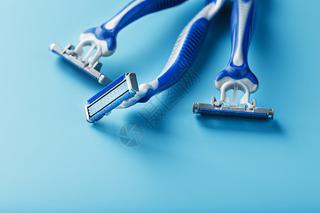 蓝色剃须机在蓝色背景上排成一行胡须剃刀塑料金属剃须刀男人工作室安全刀刃洗手间图片