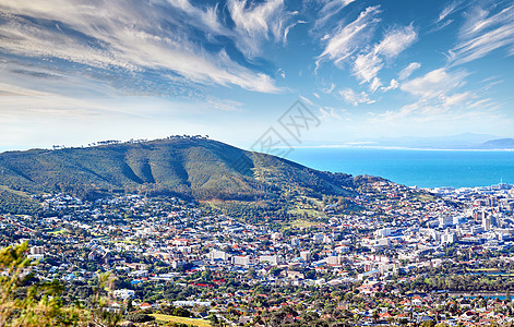 从南非开普敦的信号山看到的沿海城市的景色中 复制了多云的蓝天空间 依山傍海的城镇建筑全景景观背景图片