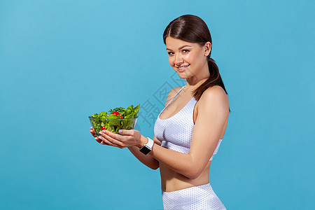 体育 医疗保健 对蓝背景年轻女性的室内拍摄训练福利蔬菜健身房运动员重量排毒食物运动肌肉图片