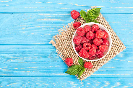 草莓在碗里蓝色树叶水果覆盆子白色甜点桌子红色食物营养图片