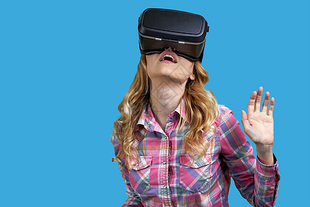 年轻女性穿着彩色背景的虚拟现实头盔图片