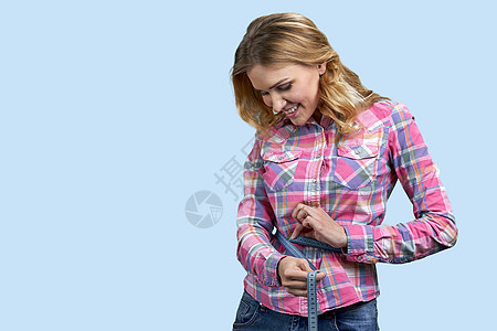 瘦瘦的年轻女人用胶带测量腰部图片