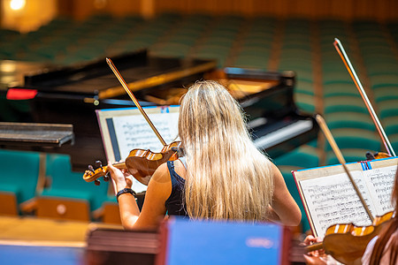 一个小提琴家在交响乐团的音乐会上演奏字符串天赋交响乐旋律仪器演员细绳团体小提琴家乐队图片