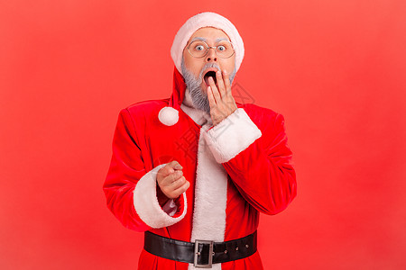 红色背景的情感年老圣诞老人条款胜利成人惊喜手指老年男性大眼睛检查员震惊男人图片