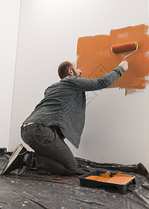 手匠在房墙壁上涂橙色油漆图片
