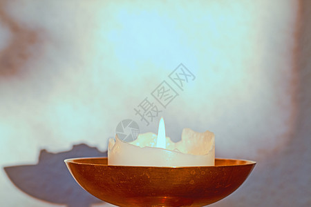 在家里的桌子上点燃一根装饰性的蜡烛以取暖 美丽的房屋装饰 用于芳香 良好的香味和照亮房间 光 照明和净化的装饰图片