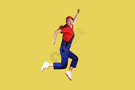 工作妇女跳跃和握紧拳头的侧面肖像 庆祝期待已久的休假日图片
