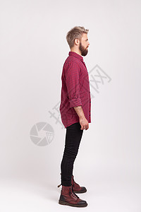 身穿红色格子衬衫和黑短裤装扮 练习模特的有严重自信的长胡子男子全身全侧视线图片