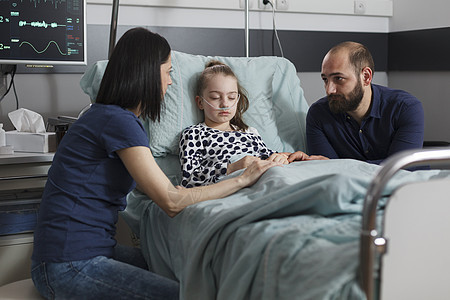父母在生病女儿住院时坐在住院的病女旁边图片